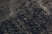 istock dark muddy road background with tire traces, dirty ground 1440016307