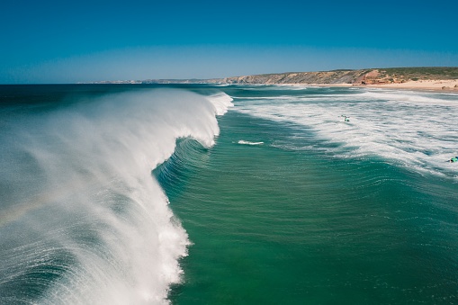 Aljezur, Portugal - October 3, 2020: People Surfing at Praia d'Arrifana Beach, surf paradise at Vicentine Coast, Algarve, Portugal