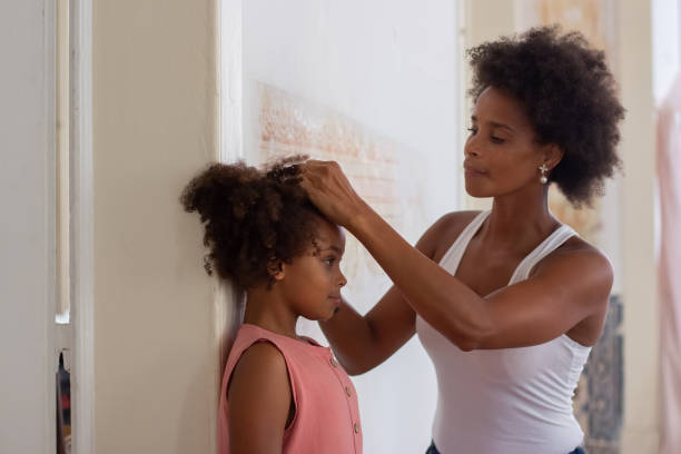 istock African American mom measuring daughters height 1440017268