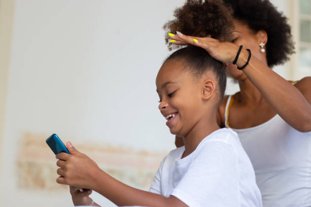 istock Jolly mother brushing daughters hair 1440017450