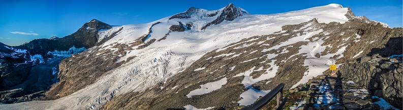 A low angle shot of a snowy mountainous scenery under the clear sky in Grossvenediger, Austria.