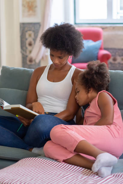 istock Loving young mother reading book to daughter 1440017622