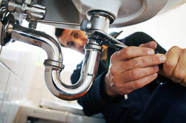 close-up of plumber repairing sink with tool in bathroom - bijstellen fotos stockfoto's en -beelden