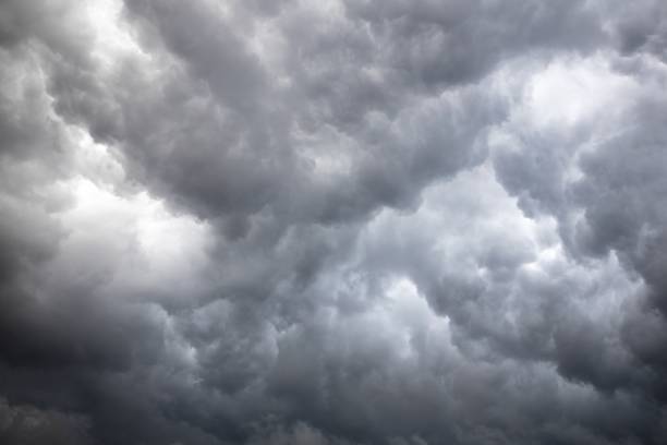 istock Low angle shot of the sky with fluffy and dark clouds 1440020560