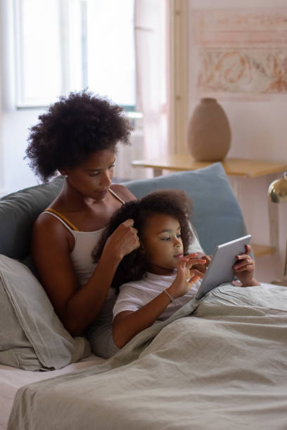 istock Relaxed mother and daughter lying in bed 1440020976