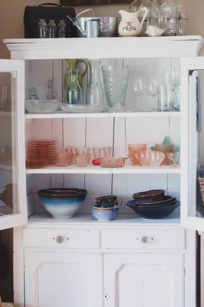 istock Vertical shot of a white shelf with different types of ceramic and glass kitchenware in it 1440022263