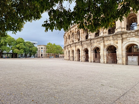The Arena of Nîmes is a Roman amphitheatre, situated in the French city of Nîmes. Built around 70 CE, shortly after the Colosseum of Rome, it is one of the best-preserved Roman amphitheatres in the world. The image was captured during autumn season.