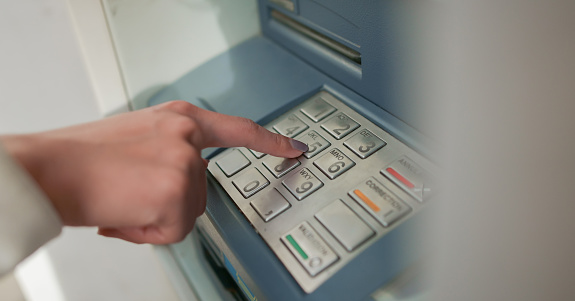 close up woman hand pressing number on atm machine for withdraw or deposit cash (money) , business technology concept