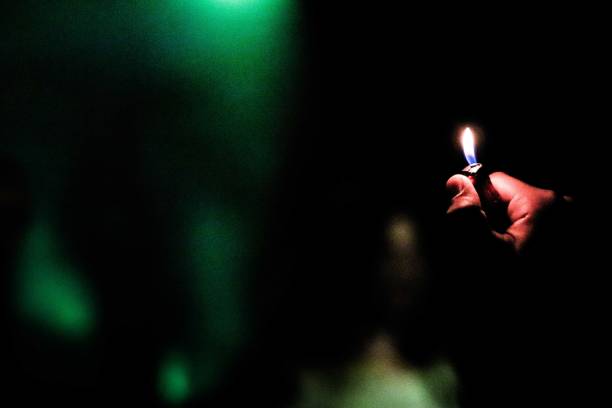 istock Selective focus shot of a person holding a lit lighter with a dark background 1440023719