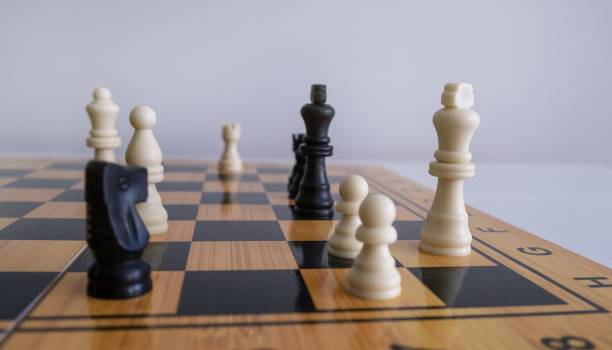 istock Closeup shot of chess figurines on a chessboard with a blurred white background 1440023937