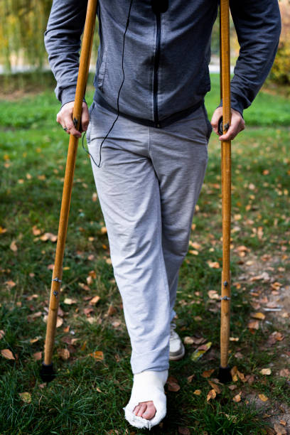 istock A young man with a broken leg, walking on crutches. 1440024049