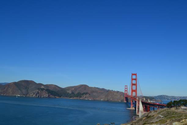 le golden gate bridge sur le plan d’eau à san francisco, en californie, sous un ciel bleu clair - san francisco county sunrise nobody sky photos et images de collection