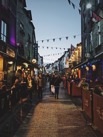 Galway, Ireland – March 09, 2018: A festive atmosphere on the streets of Galway with lots of cafes, bars, shops, and rustic decor.