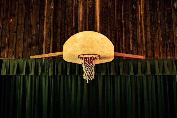 Brown and red basketball hoop near green curtains A brown and red basketball hoop near green curtains back board basketball stock pictures, royalty-free photos & images