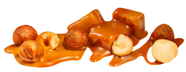 istock Caramel with nuts and sauce flowing on caramel candy isolated on white background. Top view. 1440026688