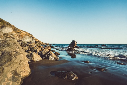 Wide view of waves crashing on shore rocks of Garrapata Beach.\n\nTaken at Garrapata Beach, Big Sur, California, USA