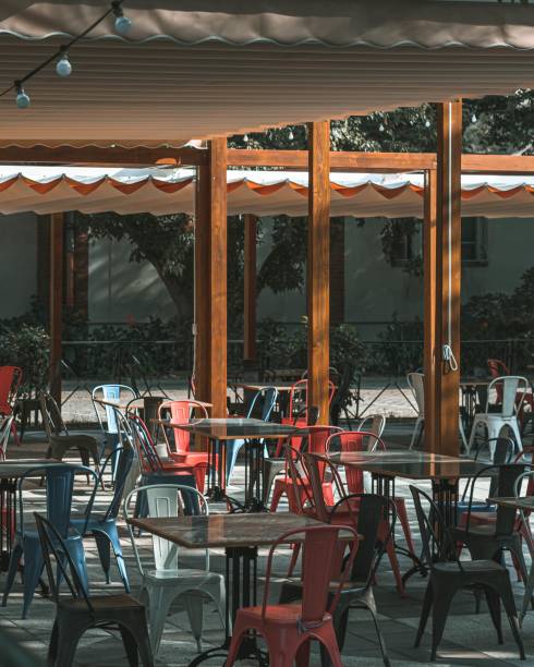 istock Outdoors empty cafe tables and chairs on a sunny day 1440027099