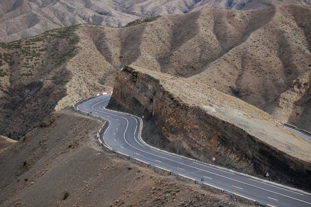 istock Curvy road around the cliff with mountains in the background 1440027552