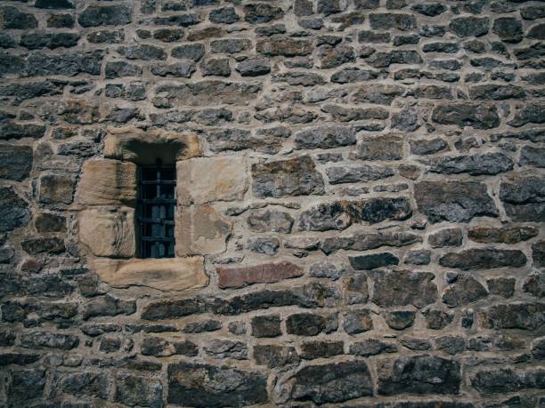 istock Beautiful shot of a stone brick old structure with a blocked small window 1440027848