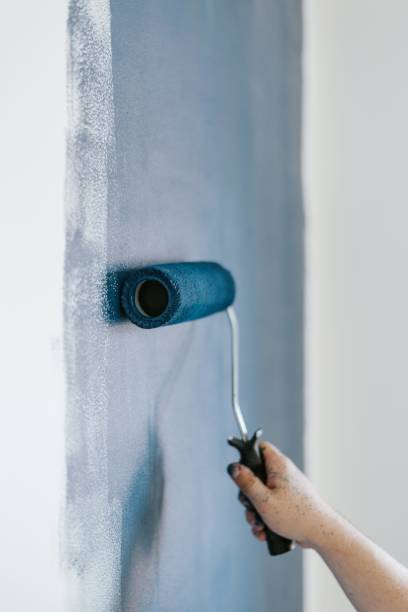 istock Closeup shot of a female using paint rollers with the color blue 1440028026