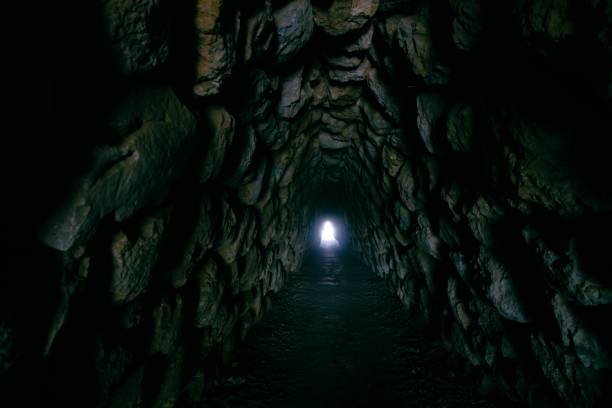 istock Rocky hallway in a cave with a light at the end 1440028822