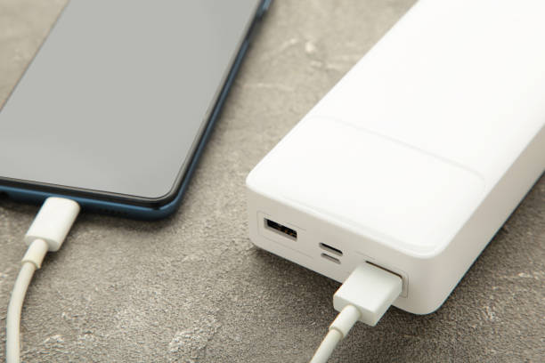 istock White powerbank charges smartphone on grey background. 1440029246