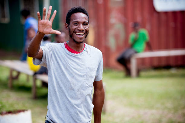 Young man waving someone happily in Papua, New Guinea Port Moresby, Papua New Guinea – May 06, 2018: A young man waving someone happily in Papua, New Guinea Papua New Guinea stock pictures, royalty-free photos & images