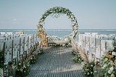 istock Wide shot of floral arch near the sea for a wedding ceremony during daytime 1440030216