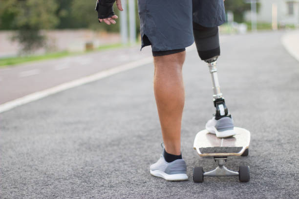 istock Back view of Caucasian man with disability riding skateboard 1440031564