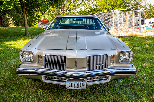 Des Moines, IA - July 02, 2022: High perspective front view of a 1974 Oldsmobile Cutlass Supreme Coupe at a local car show.