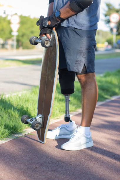 istock Man with disability holding skateboard in park 1440031737