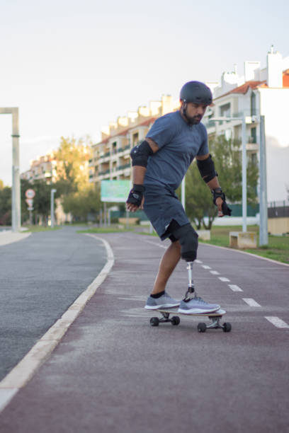 mężczyzna z mechaniczną nogą w casualowych ubraniach skateboarding - playing an instrument vertical blurred motion outdoors zdjęcia i obrazy z banku zdjęć
