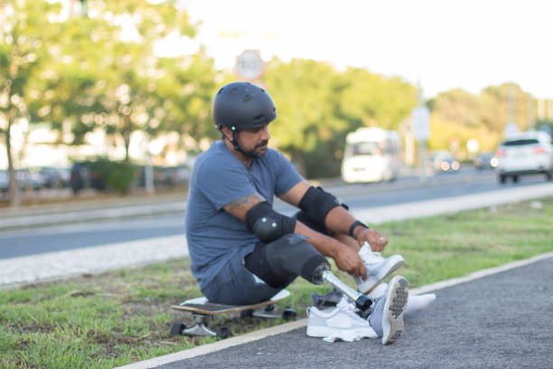 istock Person with disability tying laces in park 1440031766