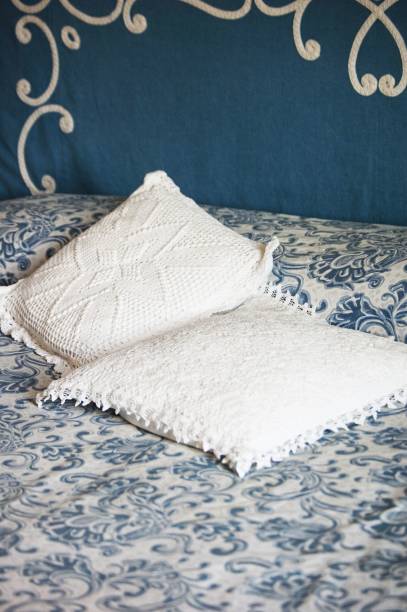 istock Vertical shot of white pillows on a bed with blue and white patterned sheets 1440032579