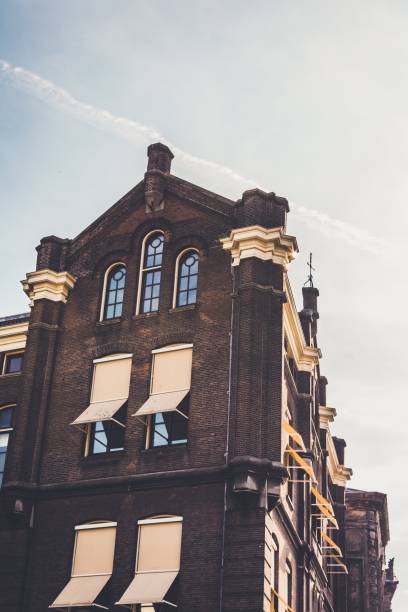 istock Vertical low angle shot of a brown and beige building under a clear sky 1440032981