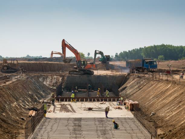 istock Close shot of heavy machines and construction workers working on a building 1440033116