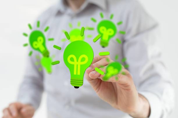 istock Man touching 3D rendered green light bulbs icon with his fingers 1440033534