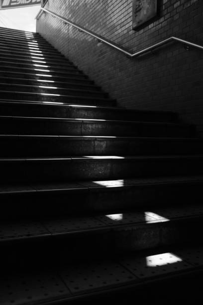 istock Grayscale vertical shot of stairs with a handrail on a brick wall 1440035193