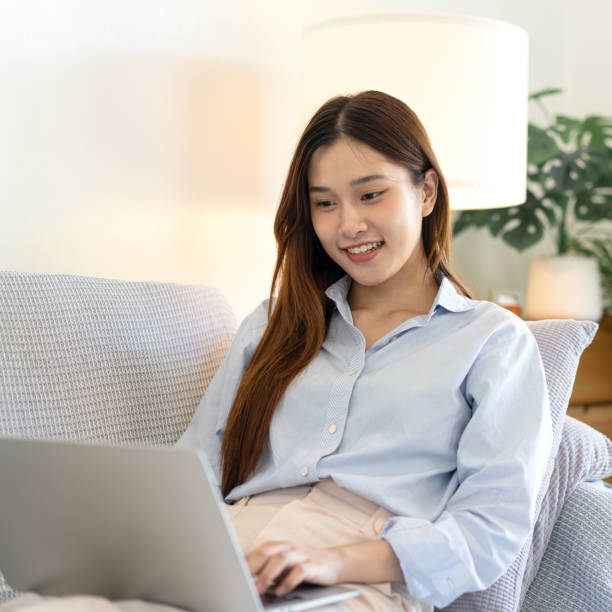 istock Female freelance is reading business data and typing information on laptop while sitting on comfortable 1440036032