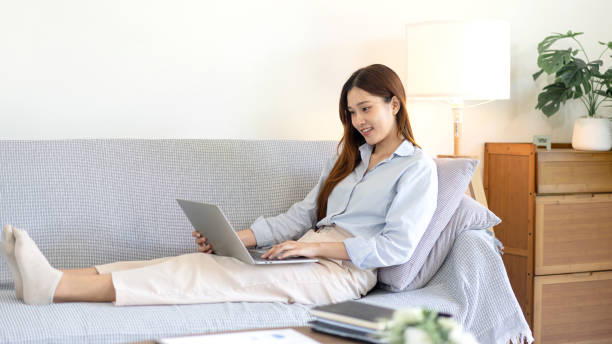 istock Female freelance is reading business data and typing information on laptop while sitting on comfortable 1440036039