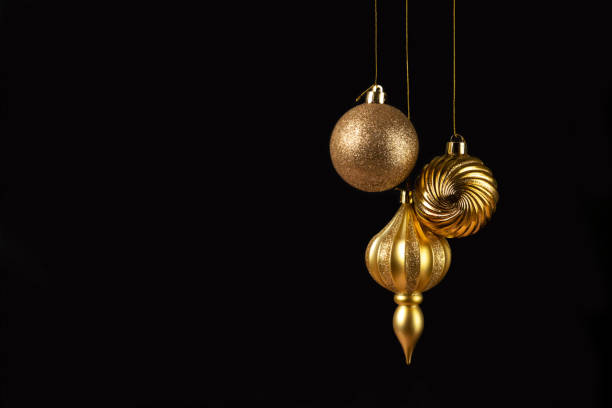 istock Christmas card with three golden decorations on black background 1440036385