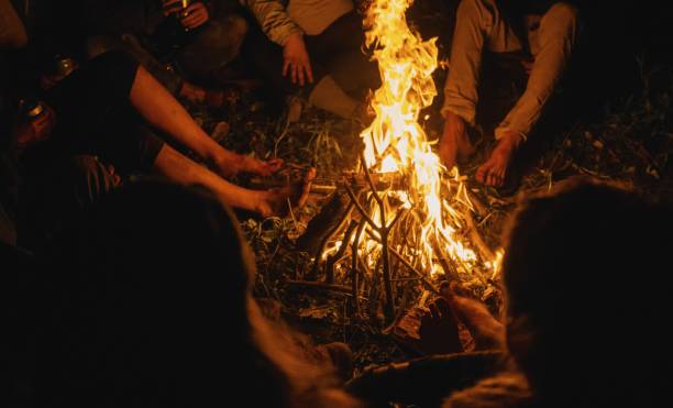 istock Selective closeup shot of people warming up while sitting around a lighted bonfire 1440036441