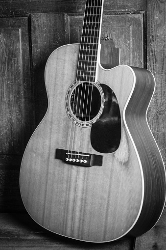 Close-up of an electric guitar on a black background. Monochrome photography. Selective narrow focus on pickup, free space for text