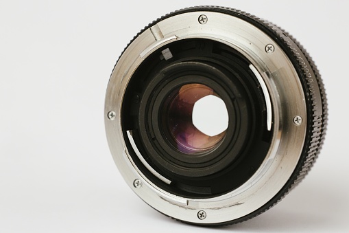 A closeup shot of a professional camera lens on a white background