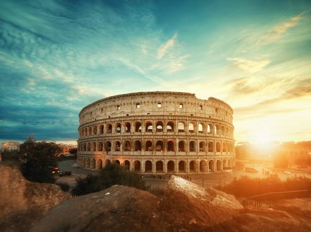 hermosa toma del famoso anfiteatro del coliseo romano bajo el impresionante cielo al amanecer - empire fotografías e imágenes de stock