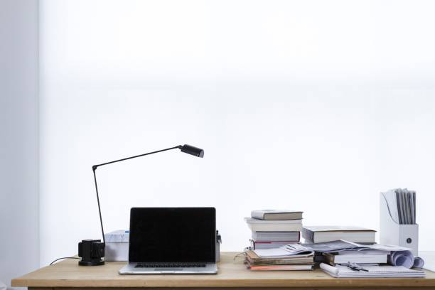 istock Work desk with a lamp, a laptop, books, and papers on it with a white background 1440037936