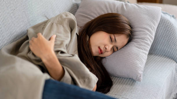 istock Female employee is lying on comfortable the couch with having chills and fever while feeling stressed 1440038595