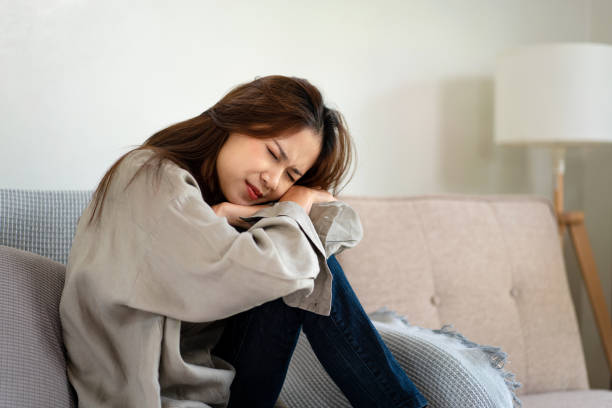 istock Female employee is sitting on the couch and headache while feeling stressed and disappointed having 1440038988