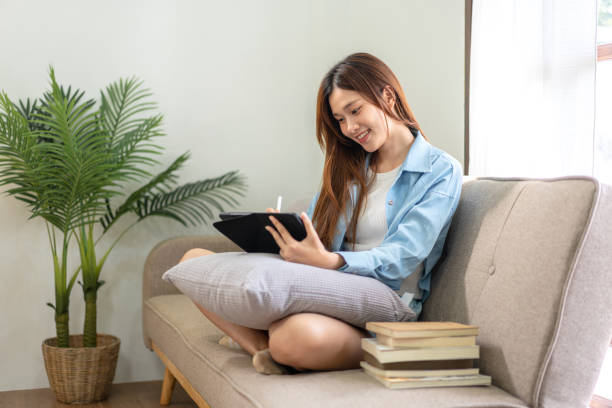 istock Young woman is analyzing strategy goal of business and taking notes on tablet while working on comfortable 1440039055