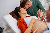Happy pregnant couple on ultrasound scanning.